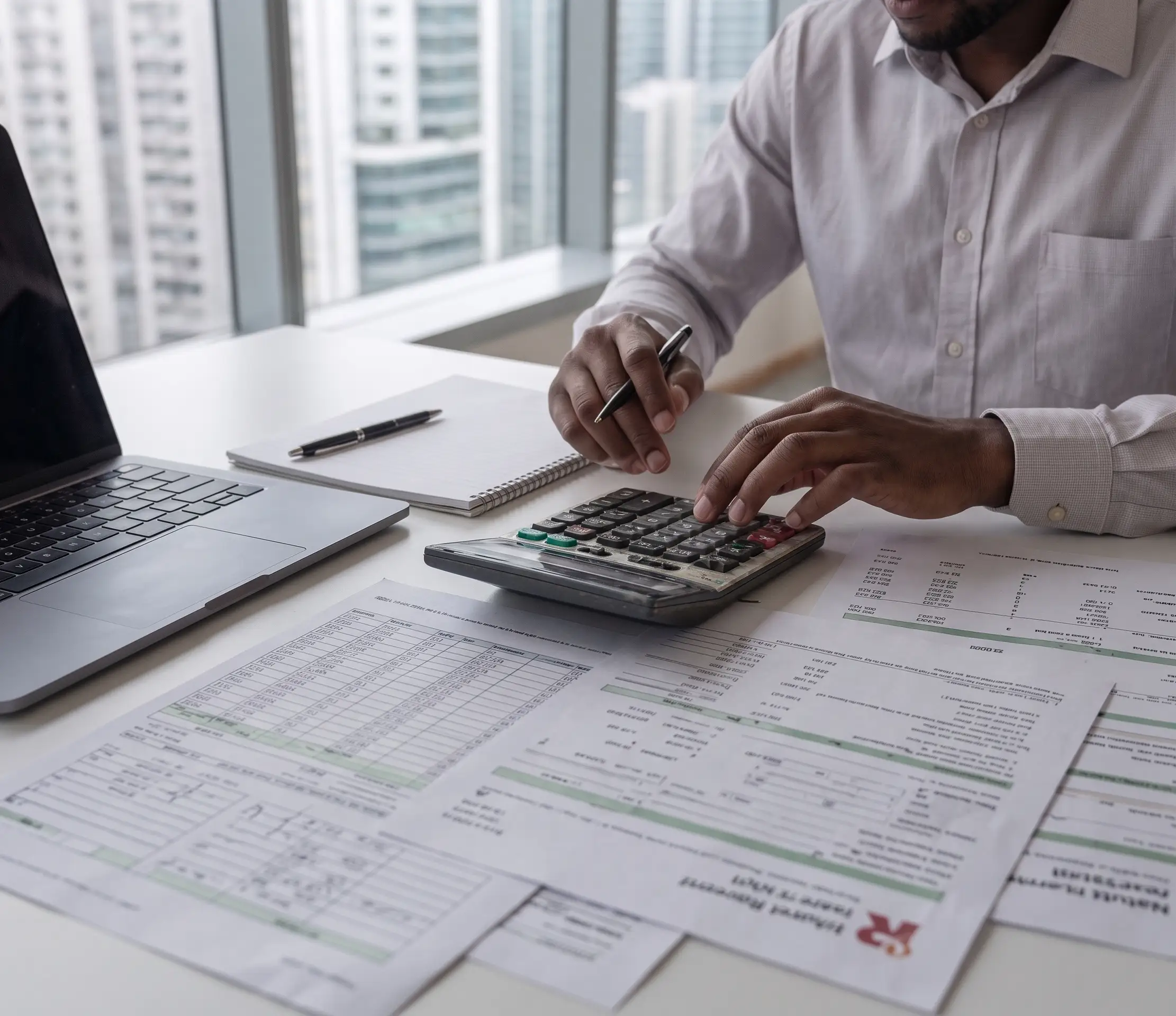 accountant reviewing financial reports and documents at clean desk with calculator and charts, profe